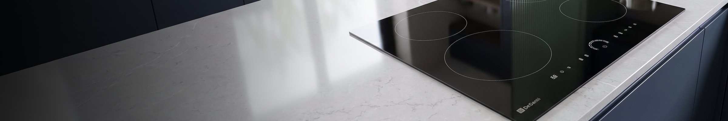 DeSantii 60cm black induction hob set into a pale marble worktop with navy cabinets